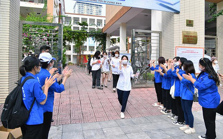 Lực lượng thanh niên tình nguyện chúc mừng các thí sinh hoàn thành Kỳ thi sau buổi thi môn Ngoại ngữ chiều 8/7 tại điểm thi Trường THCS Lê Ngọc Hân (Hà Nội). (Ảnh MỸ HÀ)