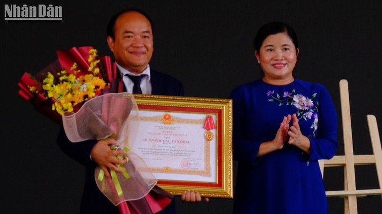 Chủ tịch Ủy ban nhân dân tỉnh Bình Phước Trần Tuệ Hiền trao Huân chương Lao động hạng Ba cho Phạm Công Trường. (Ảnh: Con trai ông Phạm Công Trường nhận thay bố)