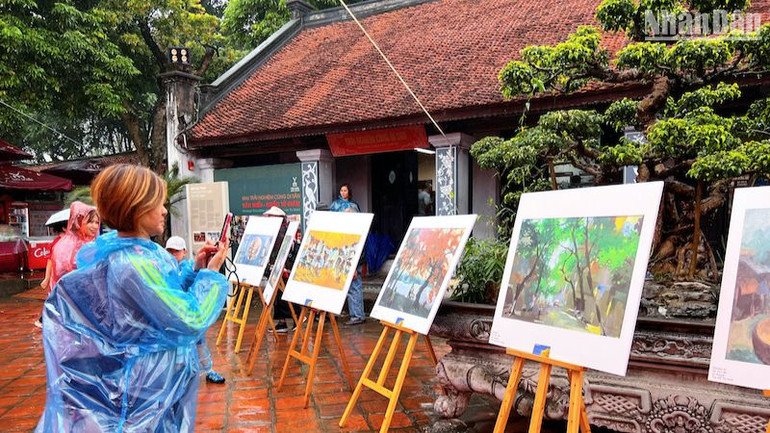 Khách tham quan thưởng lãm các tác phẩm hội họa và nhiếp ảnh đặc sắc.