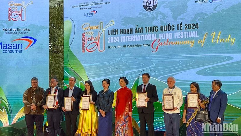 Phu nhân Ngô Phương Ly (người mặc áo dài đỏ) trao chứng nhận, vinh danh đóng góp của các Đại sứ quán tham dự Liên hoan.