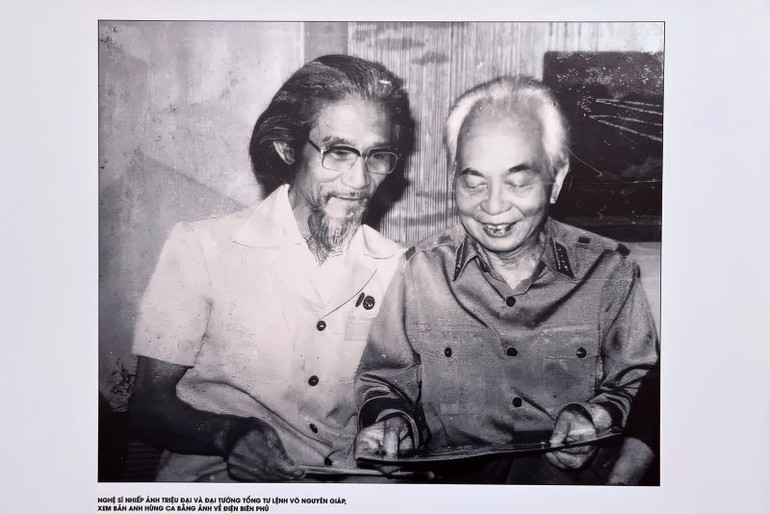 Nghệ sĩ nhiếp ảnh Triệu Đại và Đại tướng Võ Nguyên Giáp xem lại những bức ảnh chụp Điện Biên Phủ.