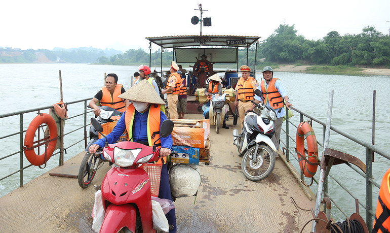 Người dân chấp hành nghiêm quy định mặc áo phao khi đi đò qua sông.