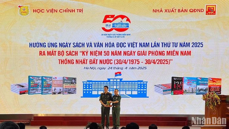 Đại tá Phạm Văn Trường (bên trái) đại diện Nhà xuất bản Quân đội nhân dân trao tặng bộ sách cho Học viện Chính trị.
