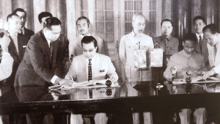 Chủ tịch Hồ Chí Minh và Hoàng thân Souphanouvong chứng kiến Thủ tướng Chính phủ nước Việt Nam Dân chủ Cộng hòa Phạm Văn Đồng (bên phải) và Thủ tướng Chính phủ Vương quốc Lào Xu-văn-na Phum-ma (bên trái) thông qua tuyên bố chung Việt Nam-Lào, Hà Nội, ngày 28/4/1961.