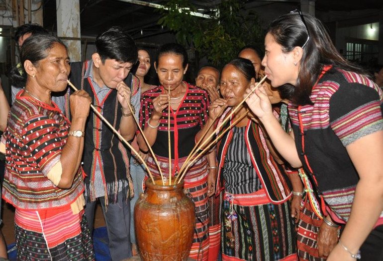 Dân làng cùng du khách uống rượu cần và thưởng thức các lễ vật.