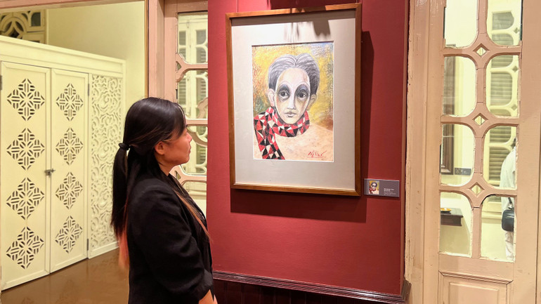 Người xem chiêm ngưỡng tác phẩm "Chân dung tự họa" (sáp màu trên bìa) của cố họa sĩ Nguyễn Ngọc Thọ.