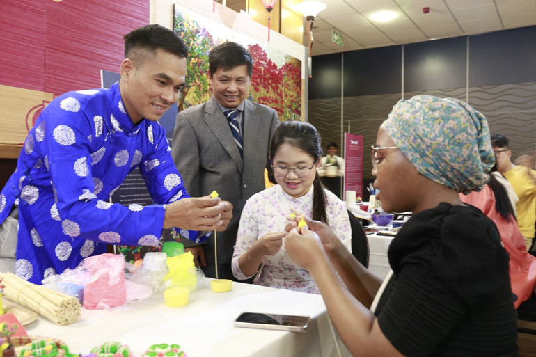 Nghệ nhân Đặng Đình Thường giới thiệu sản phẩm tò he Việt Nam và hướng dẫn khách trải nghiệm.