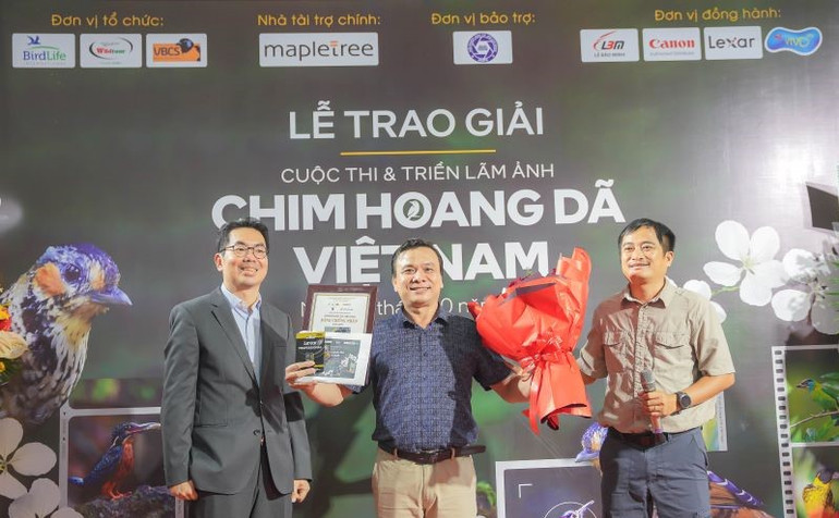 Tác giả Huỳnh Thanh Danh (đứng giữa) nhận giải cao nhất cuộc thi với bức ảnh đẹp về loài chim quý hiếm. Ảnh: Kim Liên