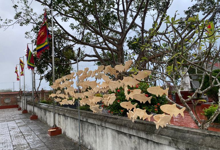 Cá gỗ trang trí mang lại vẻ sinh động cho đường làng, ngõ xóm.