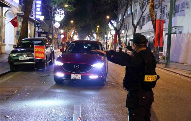 Cán bộ, chiến sĩ tổ công tác Y14/141 kiểm tra nồng độ cồn tài xế ô-tô tại tuyến phố Tràng Thi-Quán Sứ, Hà Nội. (Ảnh: TTXVN)