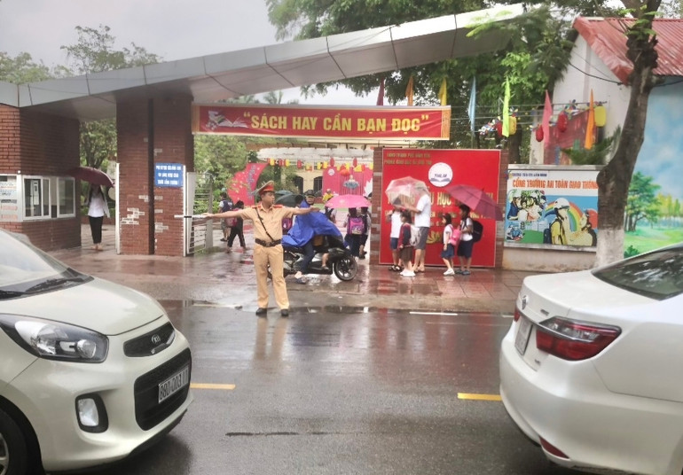 Cảnh sát giao thông thành phố Vĩnh Yên hướng dẫn giao thông tại cổng trường.