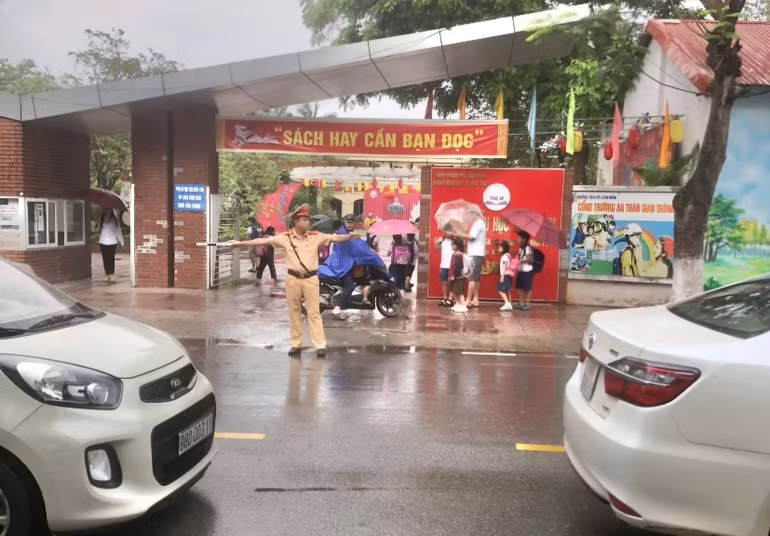 Cảnh sát giao thông thành phố Vĩnh Yên hướng dẫn giao thông tại cổng trường.