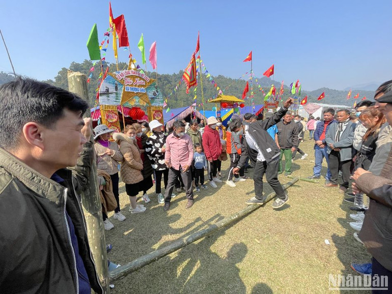 Các trò chơi dân gian thu hút nhiều người dân tham gia, mang lại những tiếng cười vui vẻ, phấn khởi. (Trong ảnh: Trò chơi đi cầu thăng bằng).