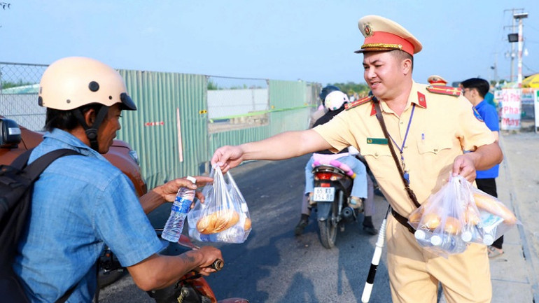 Công an tặng nước suối cho người dân.