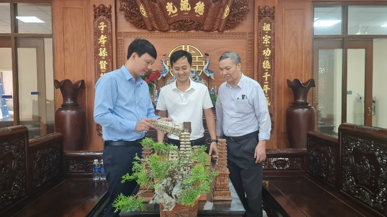 Nghệ nhân Kiều Đức Thưởng (bên trái) giới thiệu các sản phẩm du lịch lấy ý tưởng từ bảo vật quốc gia.