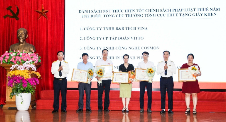 Lãnh đạo Cục Thuế tỉnh tặng giấy khen cho người nộp thuế tiêu biểu.