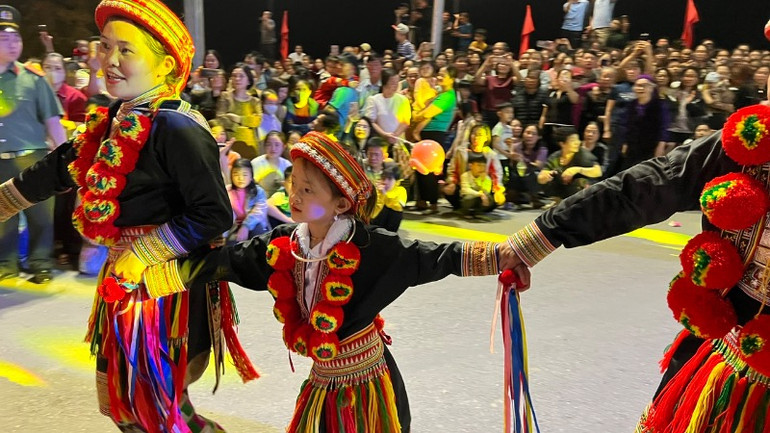 Một bé gái theo mẹ trình diễn múa dân gian. (Ảnh: TUẤN SƠN)