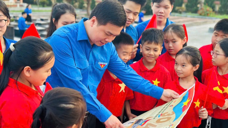 Cán bộ Tỉnh đoàn Bắc Kạn giới thiệu cho học sinh tiểu học thị trấn Phủ Thông (Bạch Thông) về nội dung phụ san đặc biệt. (Ảnh: TỈNH ĐOÀN BẮC KẠN)