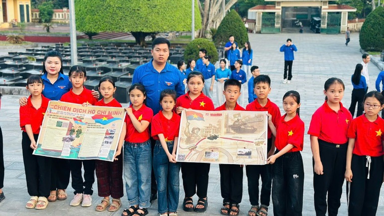 Học sinh thị trấn Phủ Thông mang theo phụ san đặc biệt tới dâng hương tại Nghĩa trang liệt sĩ tỉnh Bắc Kạn nhân kỷ niệm 50 năm Giải phóng miền nam, thống nhất đất nước. (Ảnh: TIẾN TRÌNH)