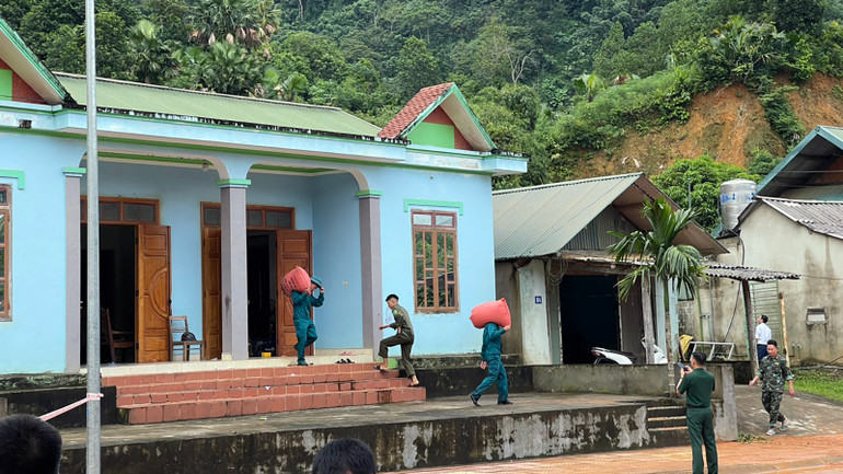 Lực lượng chức năng huyện Lâm Bình hỗ trợ di chuyển tài sản cho người dân tại thị trấn Lăng Can khỏi nơi nguy hiểm.