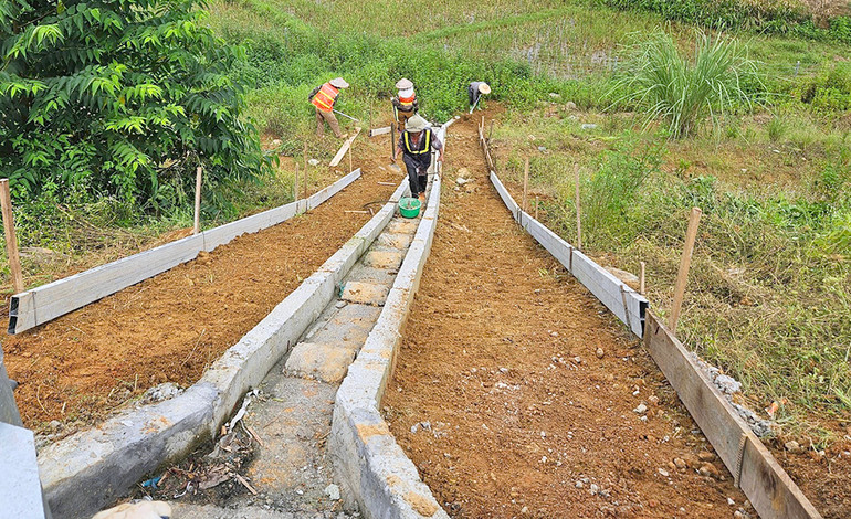 Công nhân thi công bổ sung rãnh thu nước mặt đường bê-tông xi-măng.