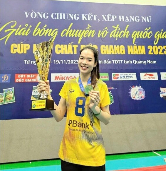 Phụ công Lê Thanh Thúy bên cúp vô địch.