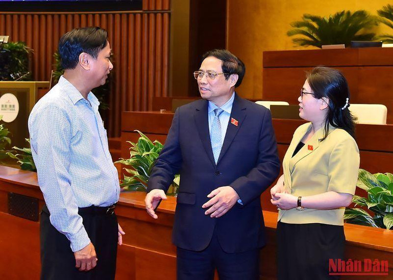 Thủ tướng Phạm Minh Chính trao đổi với các đại biểu bên lề phiên họp.