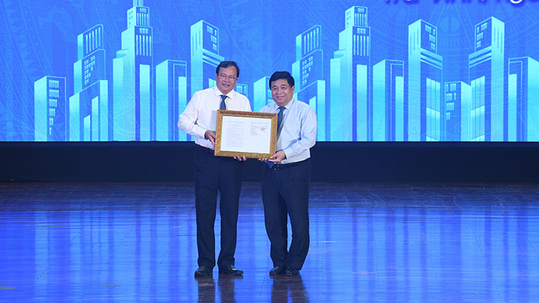 Bộ trưởng Kế hoạch và Đầu tư Nguyễn Chí Dũng thừa ủy quyền của Thủ tướng Chính phủ trao Quyết định số 1142-QĐ-TTg cho lãnh đạo tỉnh Trà Vinh.