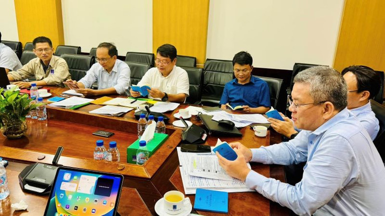 Các đại biểu xem và trao đổi về quyển sổ tay “Sửa đổi lối làm việc”.