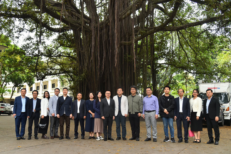 Tổng Biên tập Lê Quốc Minh, Chủ tịch Hội Nhà báo Hàn Quốc Park Jong Hyun cùng đại diện Báo Nhân Dân, Hội Nhà báo Hàn Quốc và Hội Nhà báo Việt Nam chụp ảnh lưu niệm bên cây đa Hàng Trống. (Ảnh: THỦY NGUYÊN)