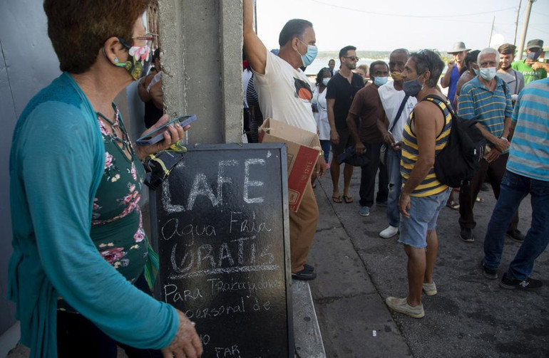 Người dân xếp hàng bên ngoài cửa hàng tạp hóa gần tiệm cà phê tặng nước và cà phê miễn phí cho những người tham gia dập đám cháy kho chứa nhiên liệu bên Vịnh Matanzas, ngày 9/8. (Ảnh: AP)