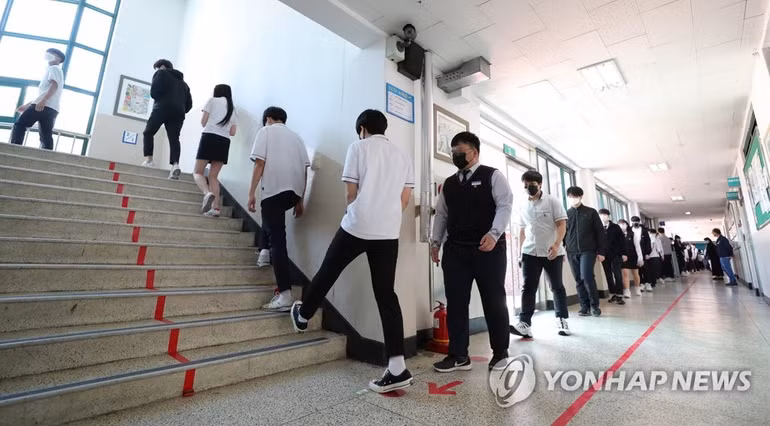 Học sinh tại một trường trung học ở Hàn Quốc giữ khoảng cách trong lúc xếp hàng vào căng-tin trong thời gian đại dịch Covid-19 bùng phát. Ảnh: Yonhap