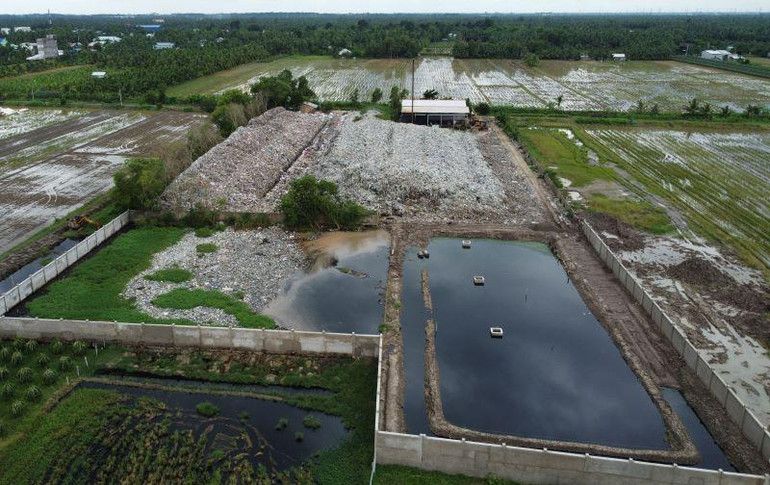 Nước rỉ rác đen ngòm tại bãi rác huyện Càng Long, tỉnh Trà Vinh, chỉ được ngăn cách bằng bức tường đơn giản với ruộng lúa.