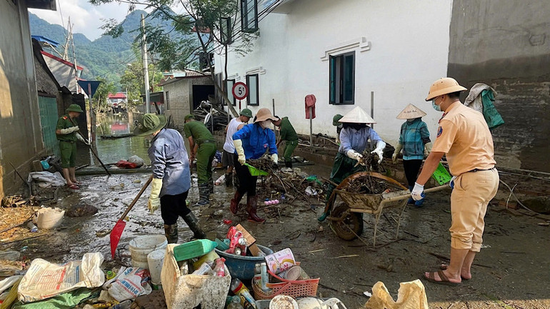 Chiến sĩ công an giúp nhân dân vệ sinh môi trường. (Ảnh: Thùy Dương)