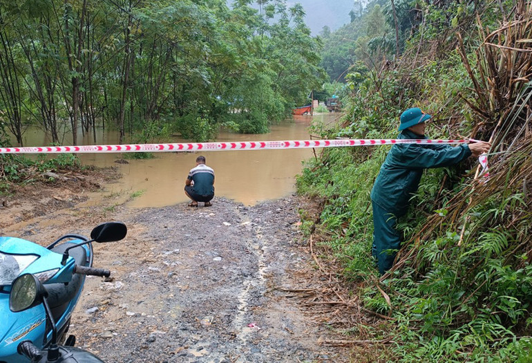 Cơ quan chức năng căng dây cảnh báo khu vực ngập lụt trên đường giao thông. (Ảnh: TRẦN LỘC).