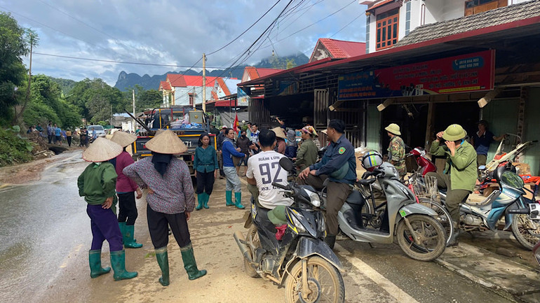 Lực lượng tại chỗ và người dân các thôn lân cận có mặt, sẵn sàng hỗ trợ di dời cho các hộ dân nằm trong vùng nguy cơ sạt lở. (Ảnh: NGỌC HÂN).