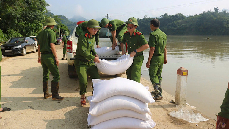 Chiến sĩ công an tỉnh vận chuyển gạo tới cho người dân vùng ngập lũ Nam Cường. (Ảnh: Thùy Dương)
