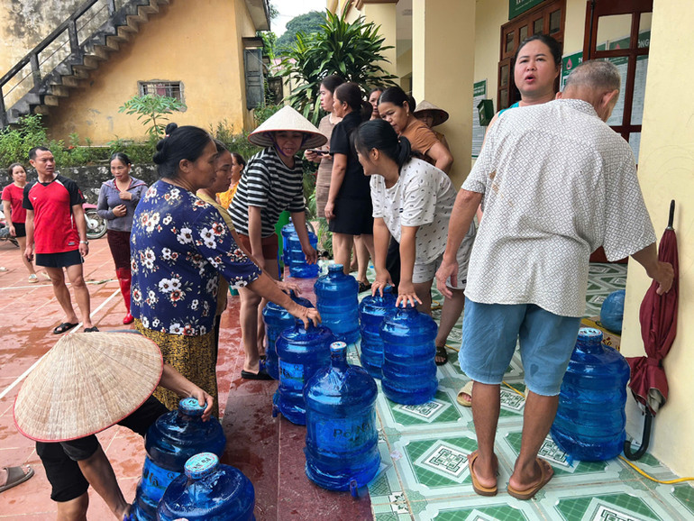 Người dân vùng ngập lụt tới nhận nước sạch.