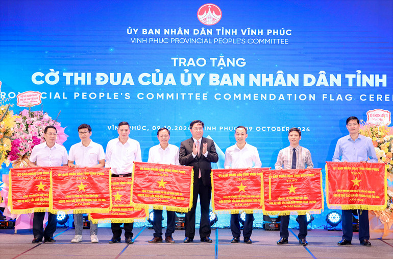 Chủ tịch Ủy ban nhân dân tỉnh Trần Duy Đông trao Cờ thi đua cho các doanh nghiệp tiêu biểu.