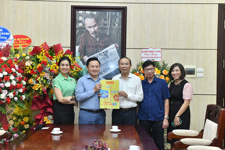 Phó Tổng Biên tập Báo Nhân Dân Phan Văn Hùng tặng Thứ trưởng Nông nghiệp và Phát triển nông thôn Phùng Đức Tiến số báo đặc biệt kỷ niệm 98 năm Ngày Báo chí cách mạng Việt Nam. (Ảnh: Đăng Khoa)