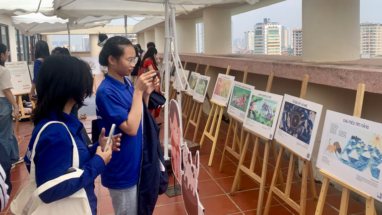 Các bạn sinh viên tương tác với các tác phẩm được trưng bày tại triển lãm.
