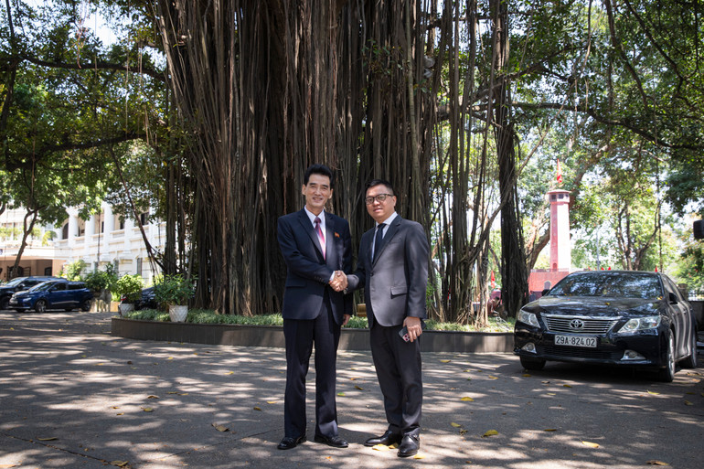 Tổng Biên tập Lê Quốc Minh và Đại sứ Ri Sung Guk chụp ảnh lưu niệm bên Cây đa 71 Hàng Trống, Hoàn Kiếm, Hà Nội. (Ảnh: SƠN TÙNG)