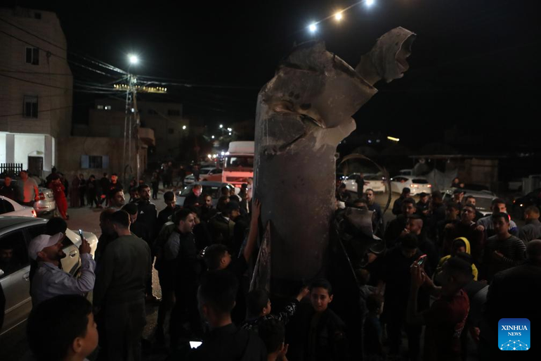 Người dân tụ tập quanh một tên lửa tại làng Dura, Bờ Tây, ngày 1/10/2024. (Ảnh: Tân Hoa xã)