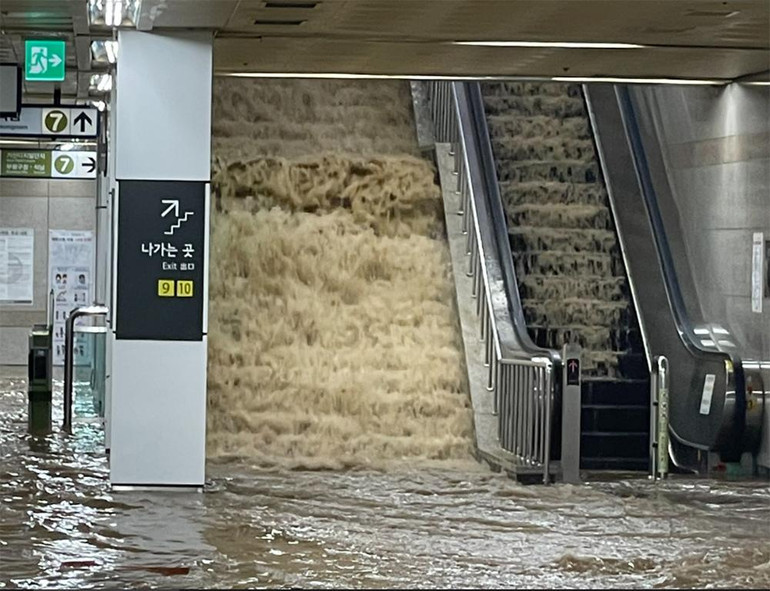 Nước mưa tràn vào ga tàu điện ngầm Isu ở phía nam Seoul tối qua. (Ảnh: Yonhap)