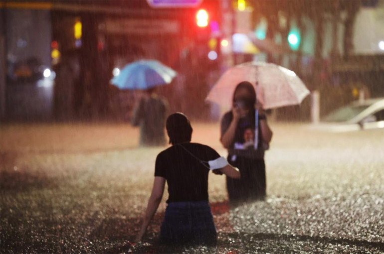 Lội nước trên đường phố tại quận Gangnam. (Ảnh: Yonhap)