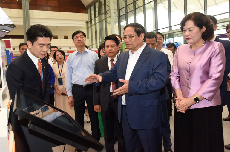 Thủ tướng Phạm Minh Chính tham quan trưng bày về ứng dụng chuyển đổi số trong lĩnh vực ngân hàng.