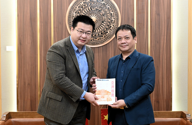 Đồng chí Phạm Song Hà nhận quà lưu niệm của đại diện Tân Hoa Xã. (Ảnh: BÙI GIANG)