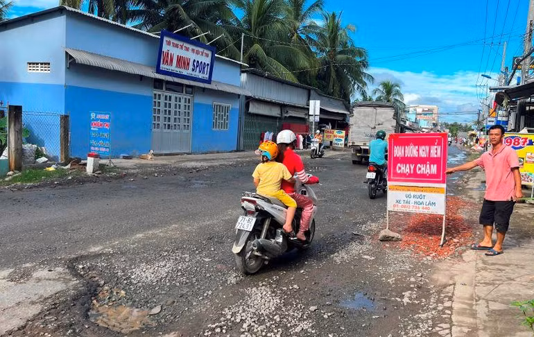 Người dân tự làm biển báo nguy hiểm do đường bị hư hỏng trên quốc lộ 57.