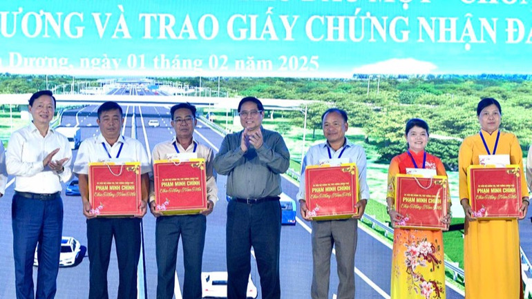 Thủ tướng Phạm Minh Chính tặng quà cho các hộ dân tiêu biểu đã bàn giao mặt bằng cho dự án. (Ảnh: THANH GIANG)
