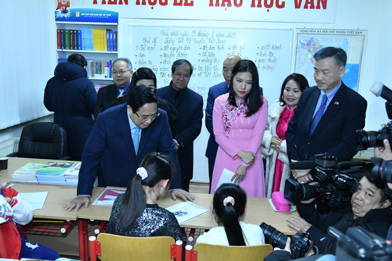 Thủ tướng Phạm Minh Chính hỏi thăm việc học tiếng Việt của các cháu học sinh của Trung tâm. (Ảnh: THANH GIANG)